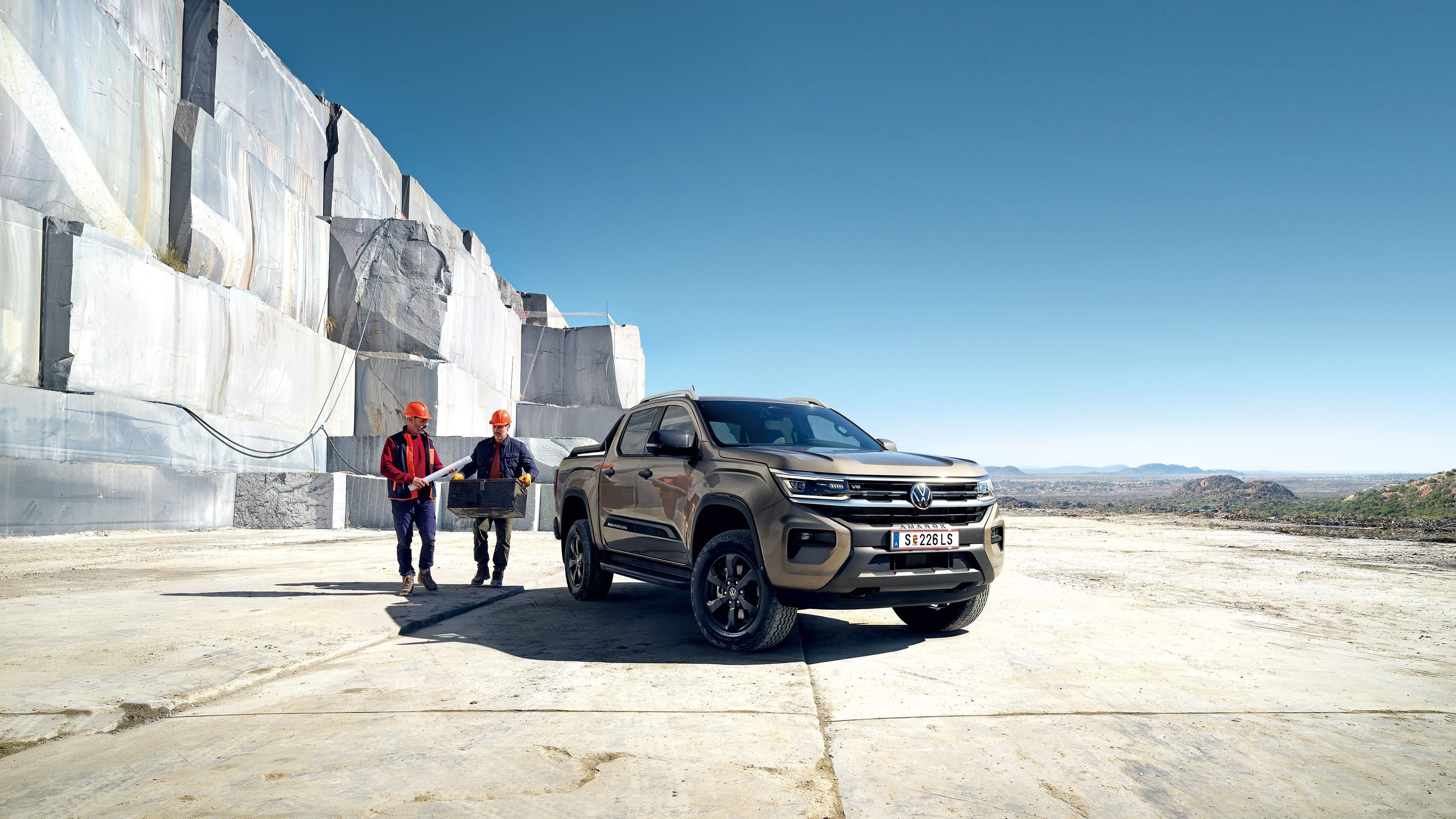 Ein VW Amarok PanAmericana steht in einem Steinbruch und zwei Männer mit Sicherheitsbekleidung sind zu sehen