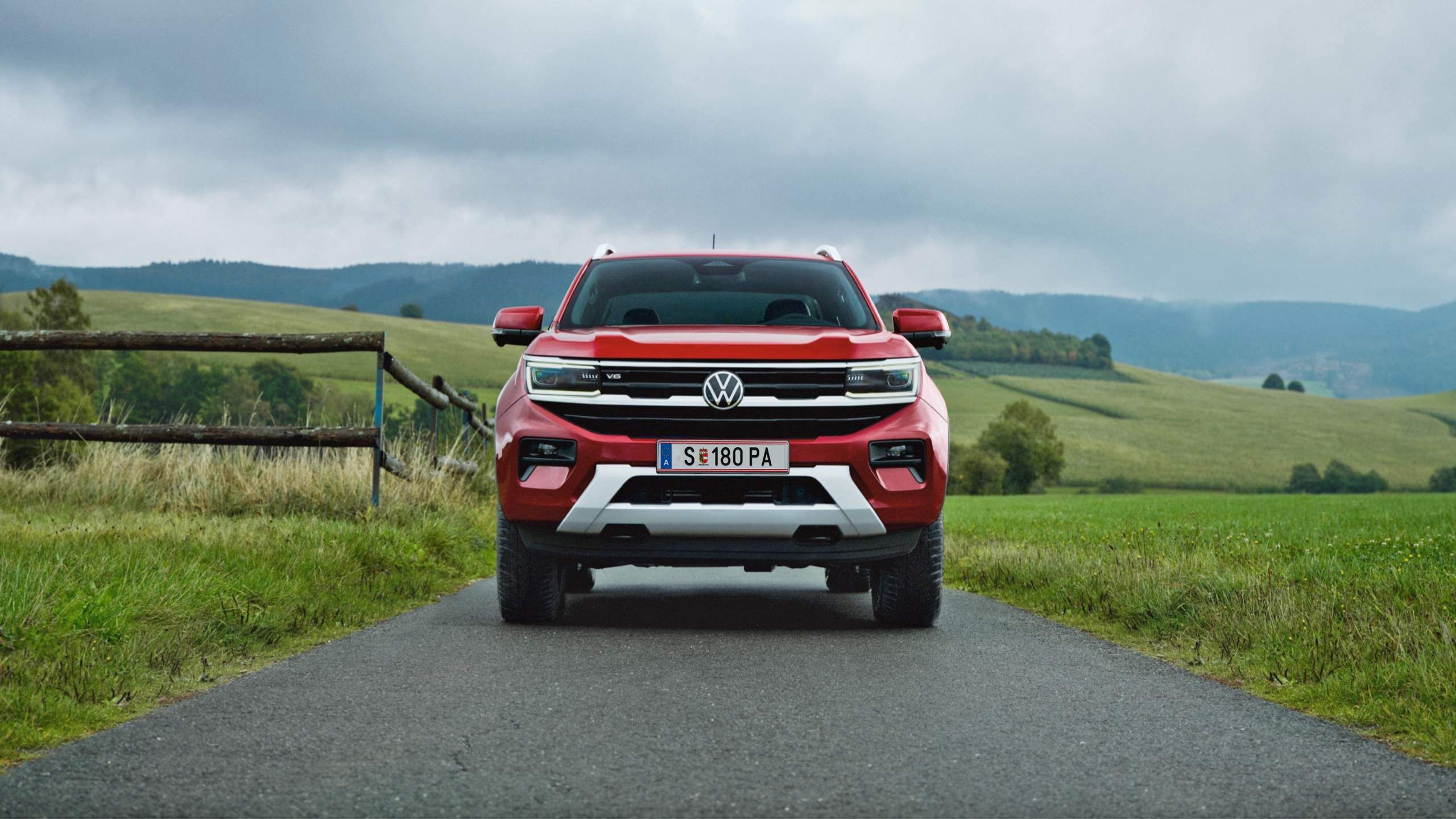 Ein VW Amarok Style steht auf einem Feldweg, im Hintergrund sind Felder, Wälder und ein Zaun zu sehen